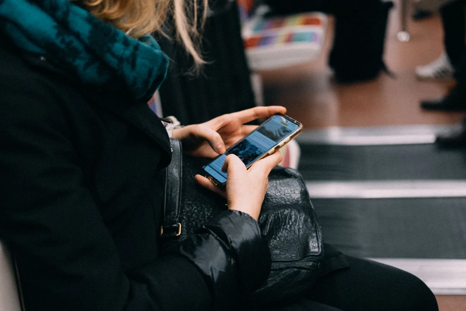 Woman using her smartphone while riding public transit, the kind of moment Siri AI in iOS 27.2 is built for