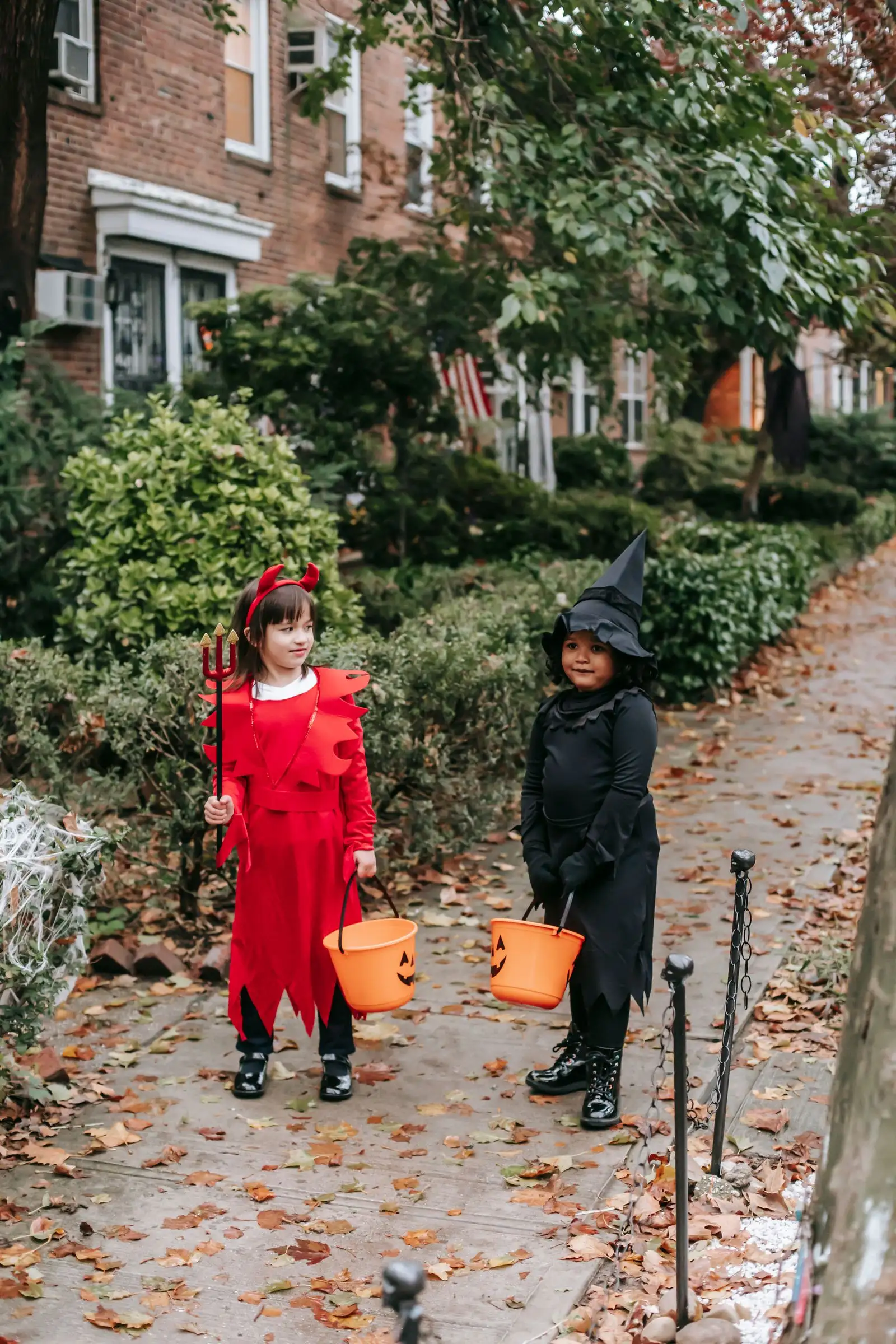 Children in witch and devil costumes walking down an autumn street, Halloween weekend things to do in Toronto